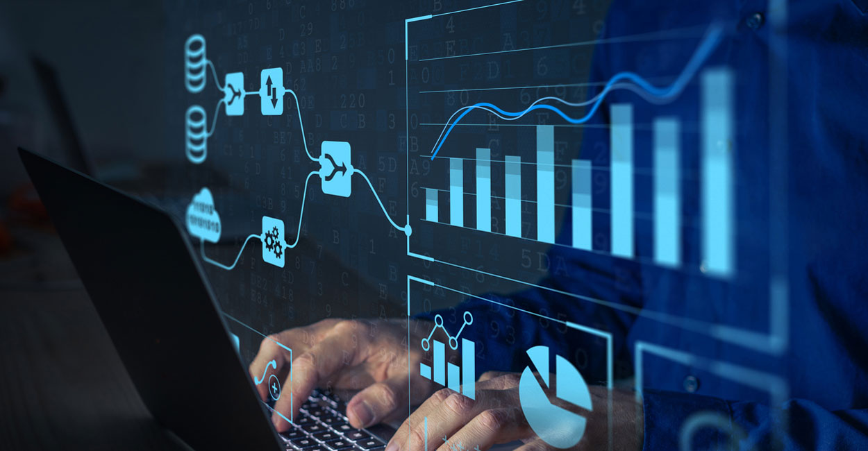 Hands typing on a laptop with translucent blue data visualizations: bars, line graphs, and analytic icons overlaid on the screen.